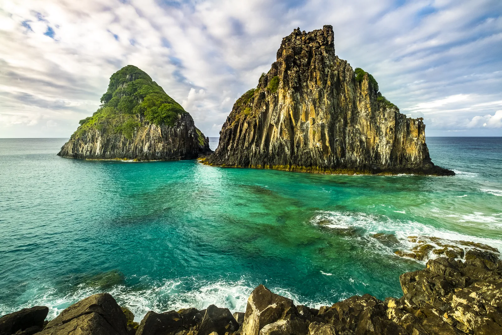 Morro Dois Irmãos e águas turquesa vistos da Baía dos Porcos, em Fernando de Noronha.