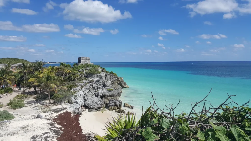 Ruína maia sobre uma falésia em Tulum, com praia e mar azul-turquesa na Riviera Maya.