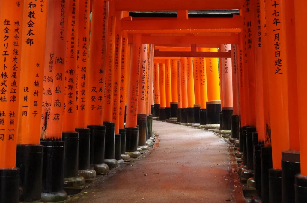 Caminho entre portais torii vermelhos no santuário Fushimi Inari, em Kyoto.