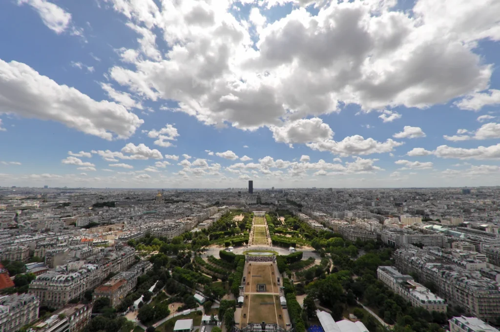 Vista de Paris a partir da Torre Eiffel, com o Champ de Mars ao centro e edifícios ao redor.