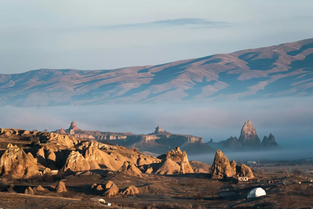 Formações rochosas da Capadócia entre a neblina da manhã, na Turquia